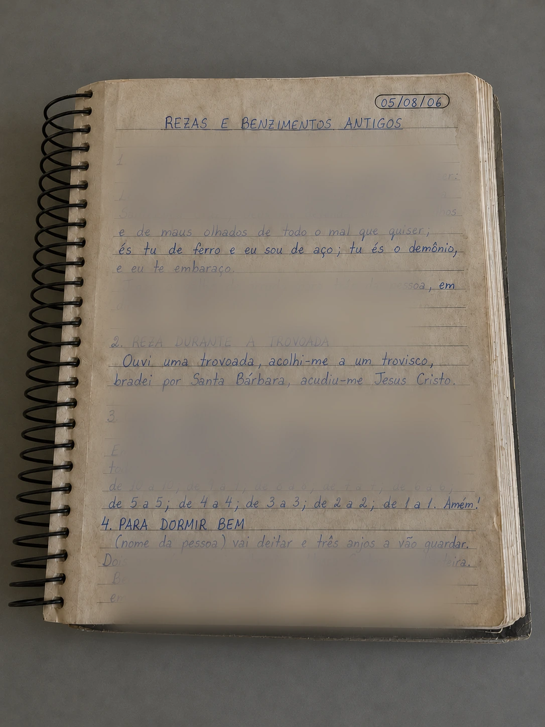 Caderno de pesquisa com registros de benzimentos e rezas